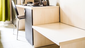 A modern office space with a desk, chair, and a vase of flowers. - Mosaic Guest House (Rome)