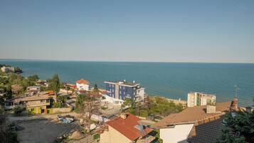 Zona residencial costera con edificios, vista despejada al mar y un estacionamiento.