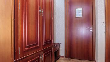Un couloir avec une armoire en bois et une porte.