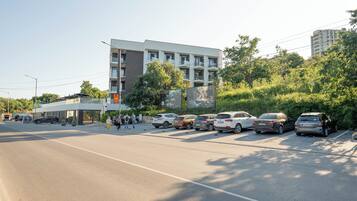 Un bâtiment moderne avec une enseigne indiquant la présence d’un spa, des voitures garées et un ciel dégagé.