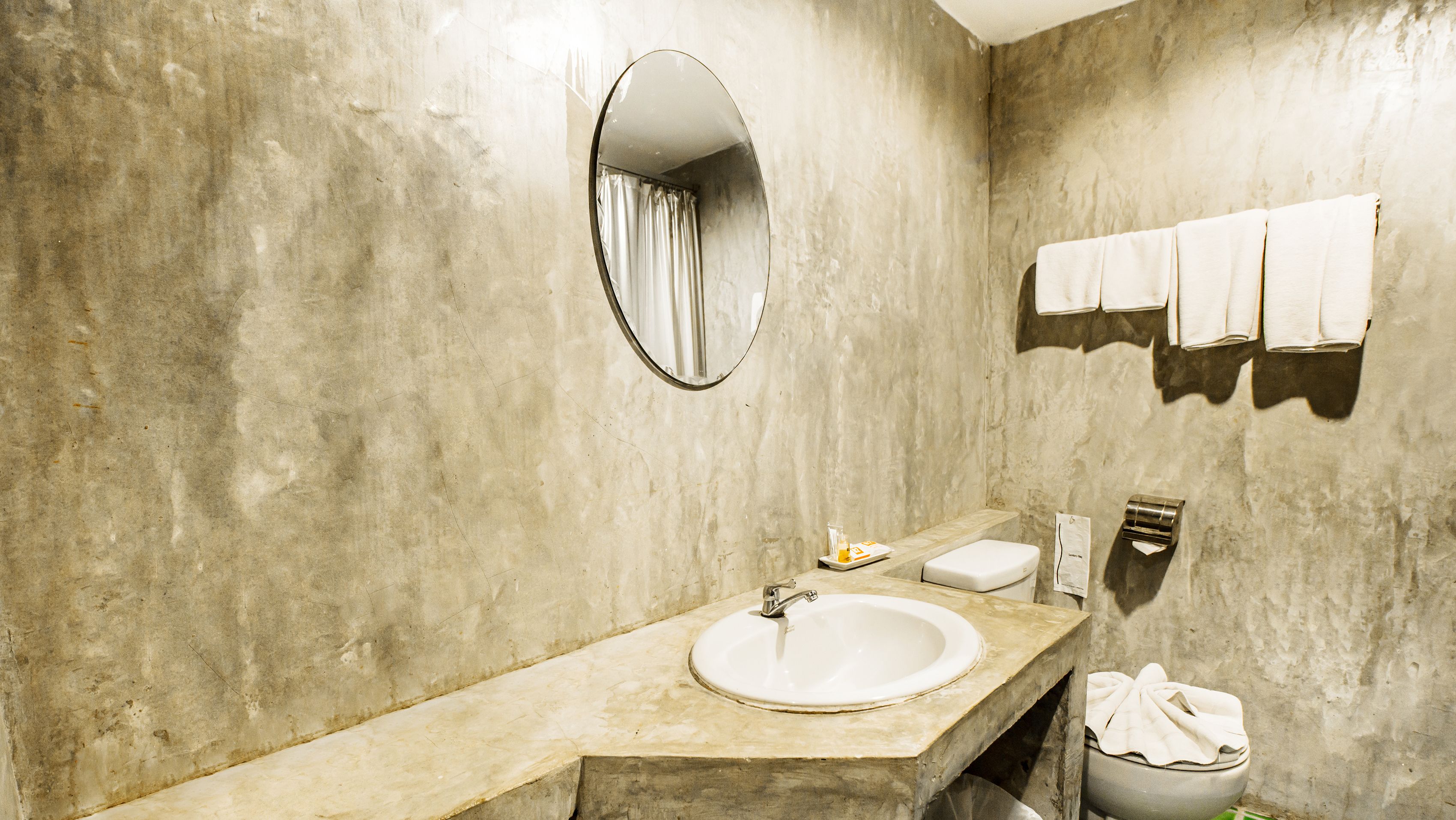 Une salle de bain avec un lavabo en marbre, un miroir, un porte-serviettes et des toilettes.