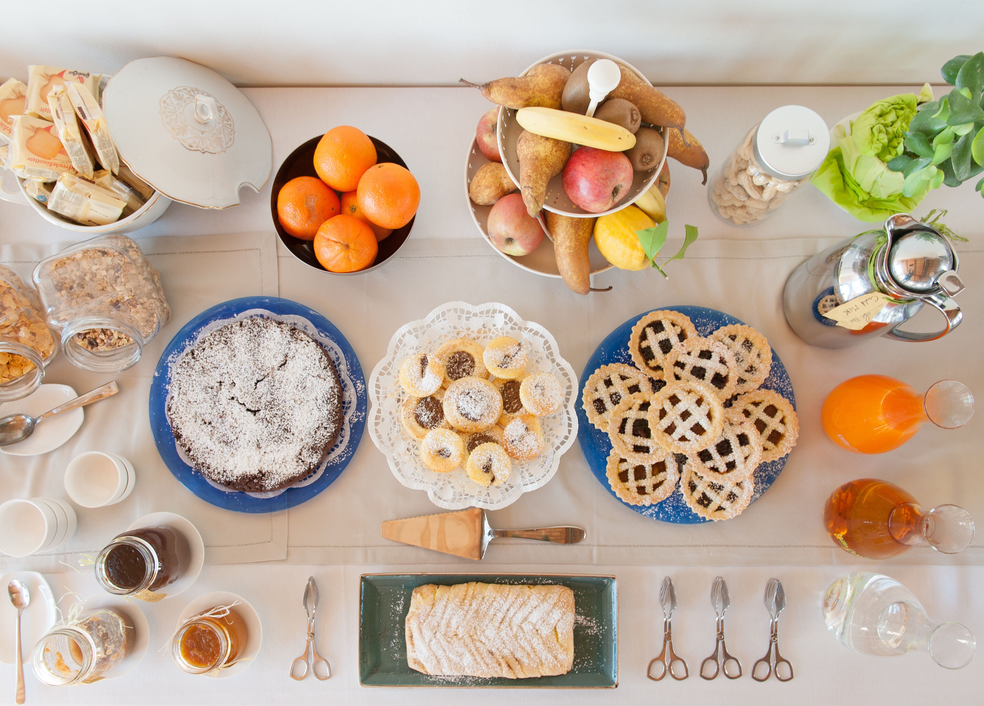 Una mesa de desayuno con diversos alimentos, utensilios y recipientes.