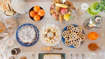 Una mesa de desayuno con diversos alimentos, utensilios y recipientes.