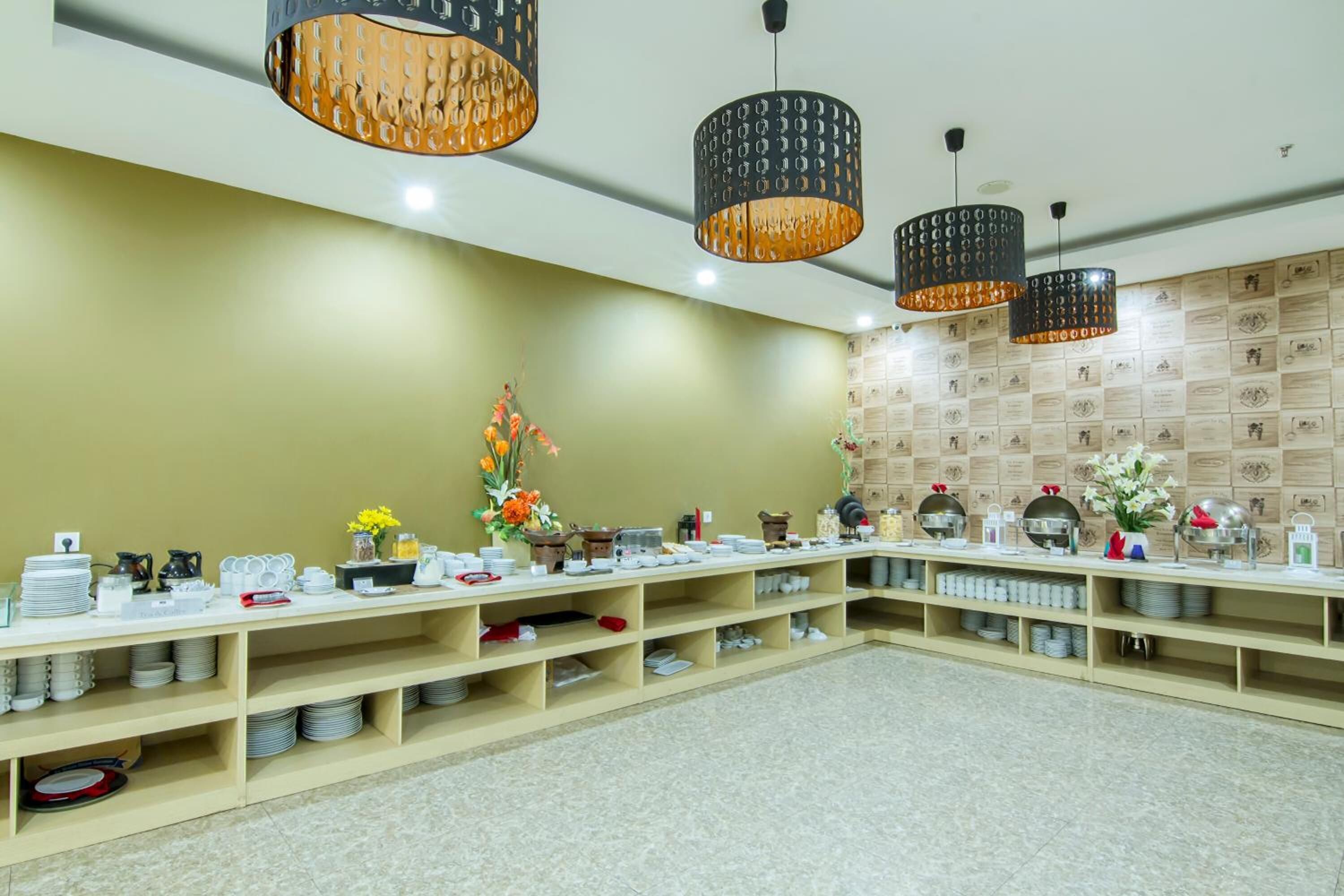 A buffet setup with multiple serving stations, a variety of dishes, and decorative flowers.