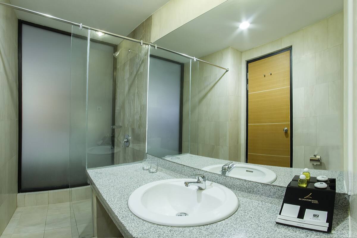 Une salle de bain moderne avec une douche à parois de verre, un lavabo blanc et un miroir.
