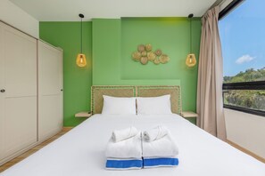 A bedroom with a bed, green walls, a window with a view, and two pendant lights. - The Lago Apartments by Tropiclook (Rawai)