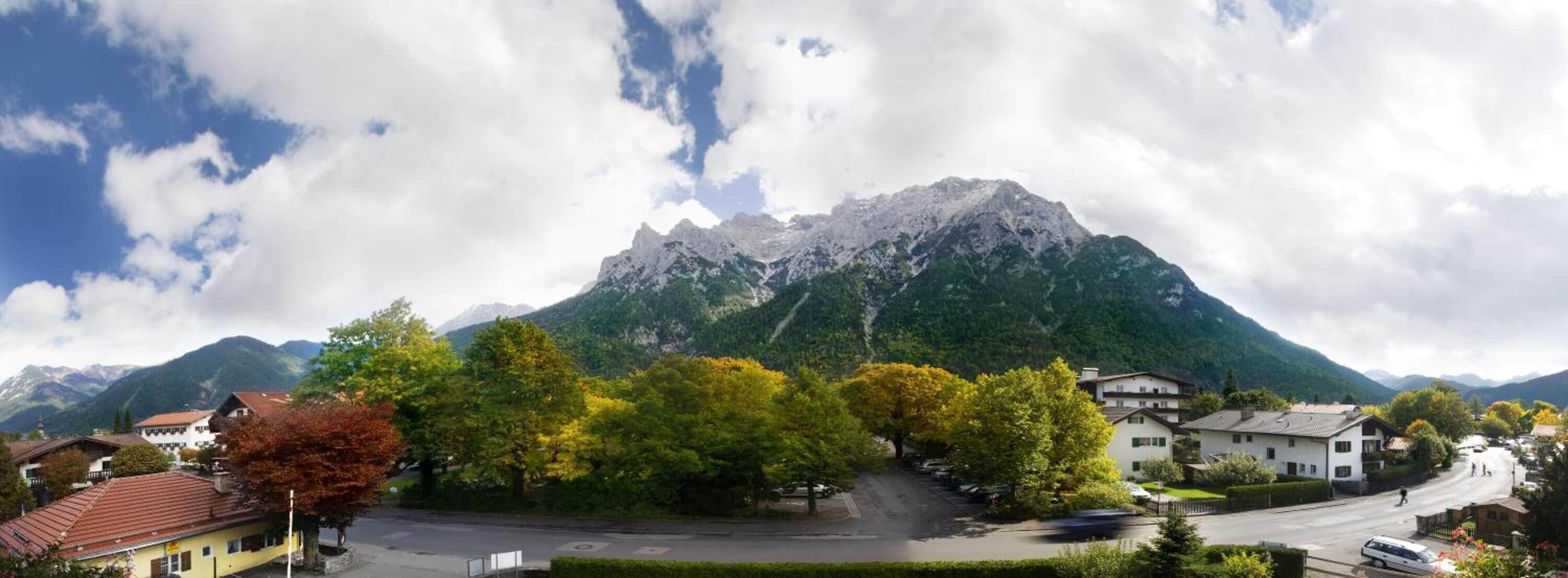 A mountain village with traditional houses, a central square, and a prominent mountain peak.