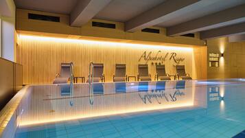 Zona de piscina con mostrador de recepción, sillas de descanso y suelo de baldosas.