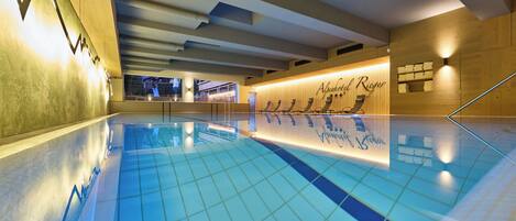 Una piscina con suelo de baldosas y una pared de madera con un letrero.