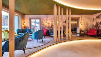 Ein modernes Interieur mit gewölbter Decke, Holzsäulen und verschiedenen bunten Stühlen.