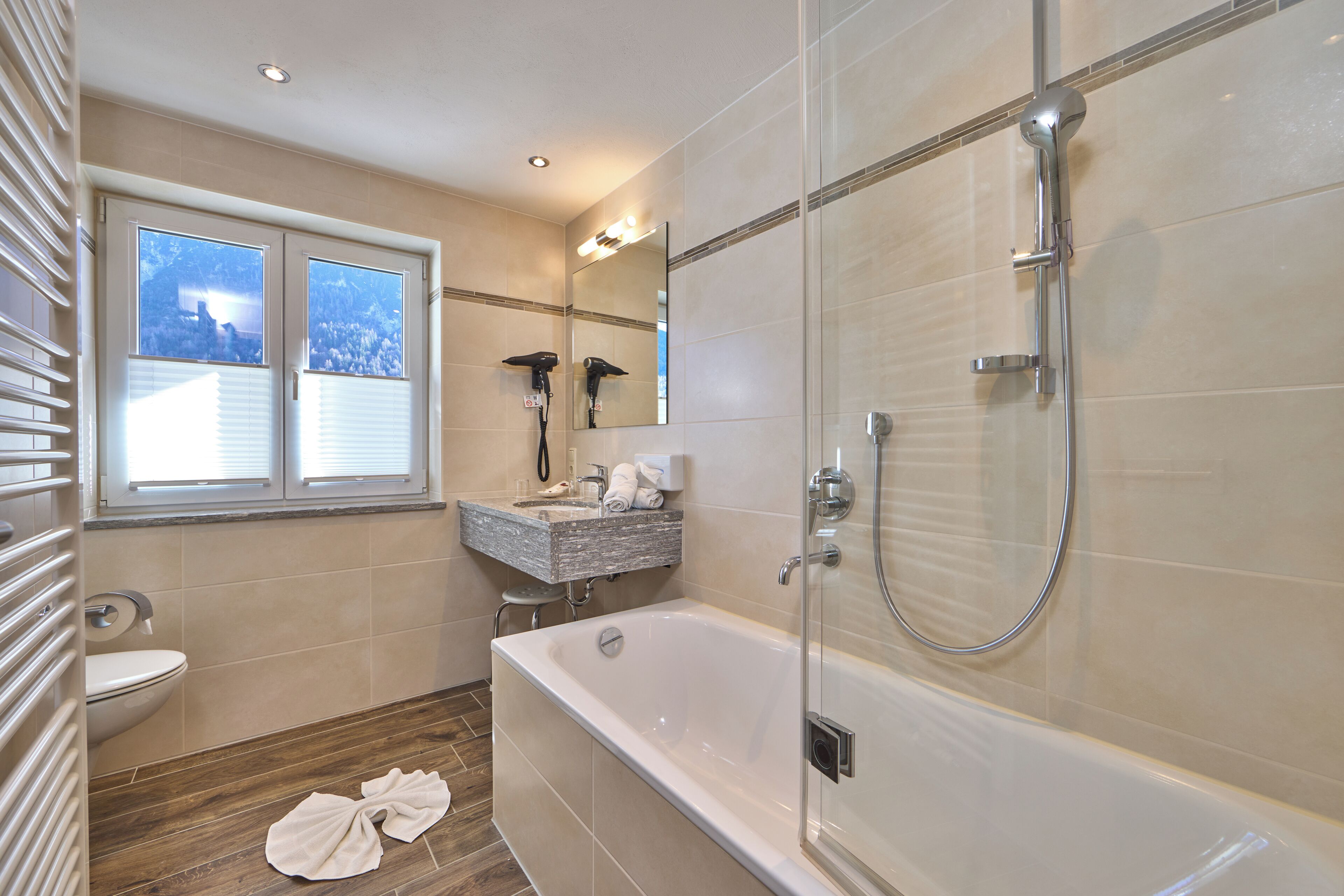 A modern bathroom with a glass-enclosed shower, a freestanding bathtub, and a vanity with a mirror.