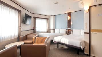 A hotel room with two beds, a sofa, a small table, and a TV.
