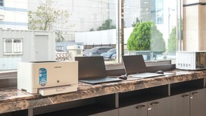 En receptionsdisk med två bärbara datorer, en Samsung-skrivare och en datormus.