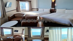 A hotel room with two beds, a sofa, a table, and a TV.