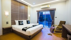 A modern hotel room with a large bed, a desk, and a chair. - The S.G Hotel (Buriram)