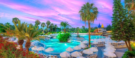 Un resort con piscina, sillas de descanso y palmeras.