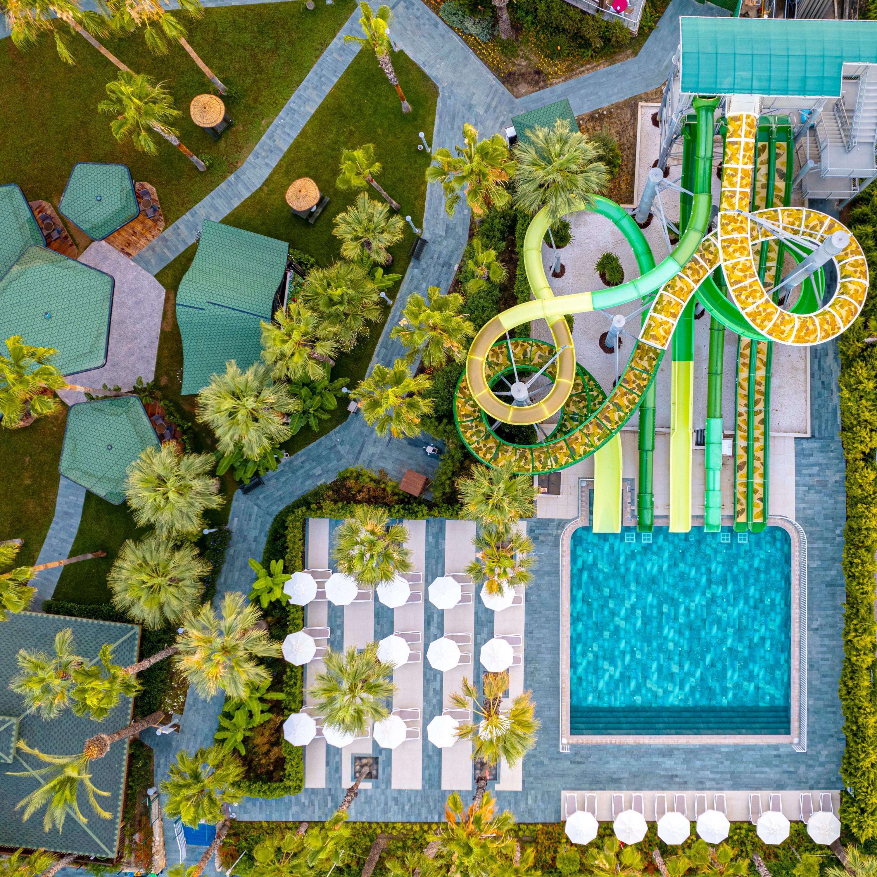 A resort with a pool, lounge area, and water slides.
