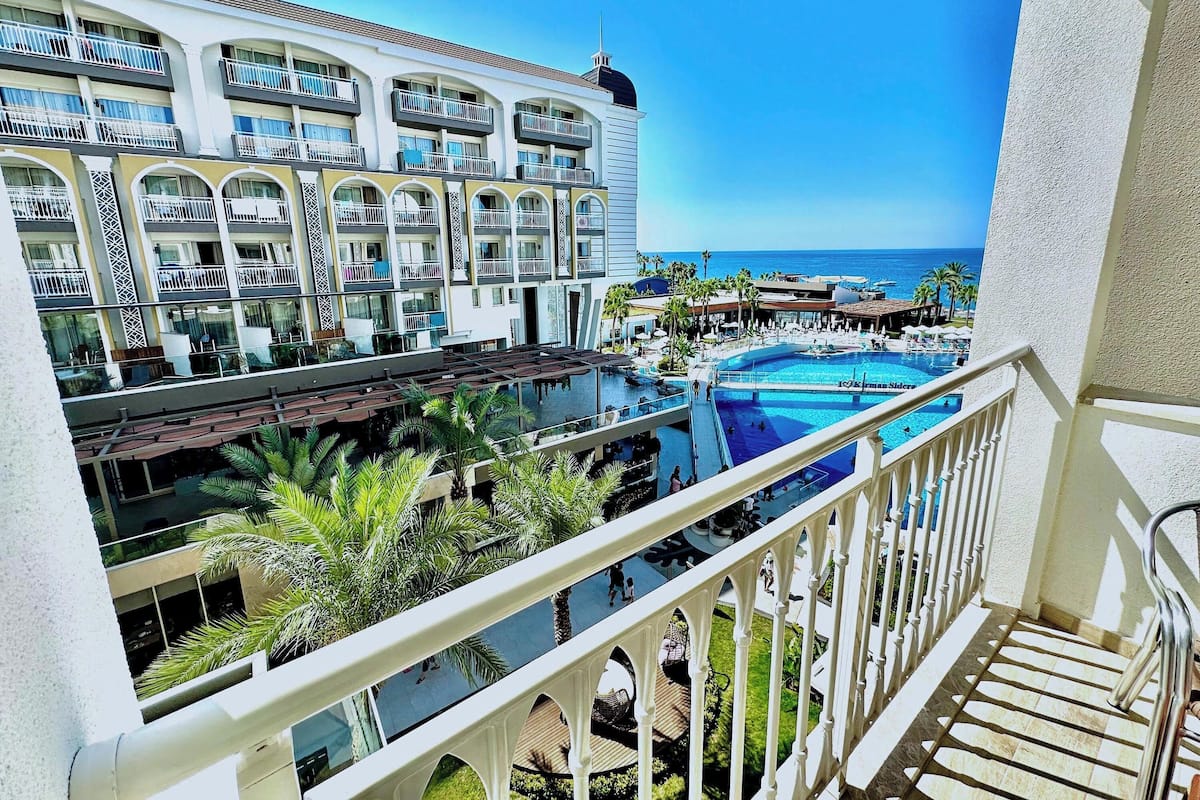 Un hôtel doté de nombreux balcons, d’une piscine et offrant une vue sur l’océan.