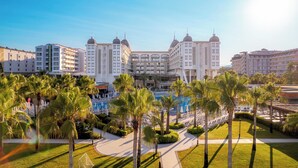 Un hôtel doté d’une cour intérieure, de palmiers et d’une piscine.