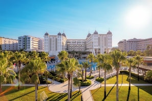 A hotel with a central courtyard, palm trees, and a pool. - Sidera Kirman Premium - Ultra All Inclusive (Alanya)