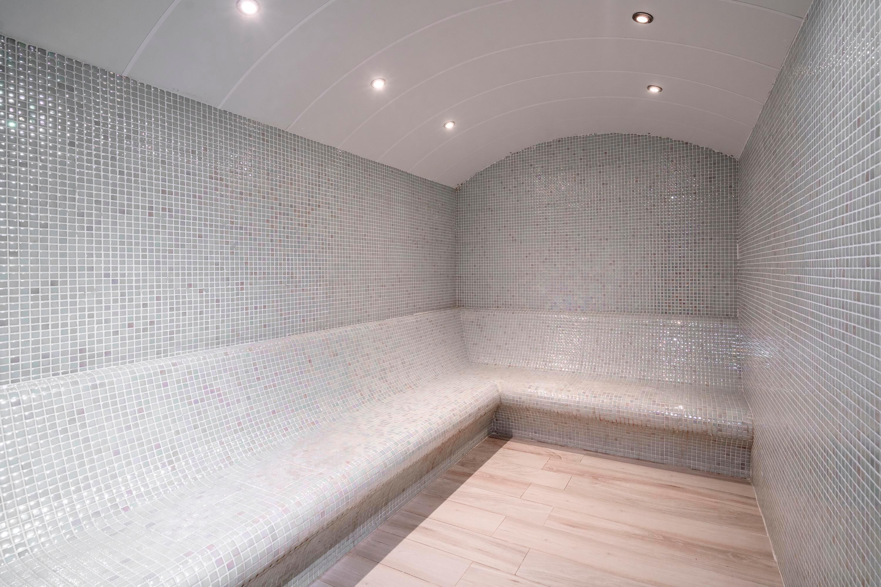 A tiled room with a bench and a small step.