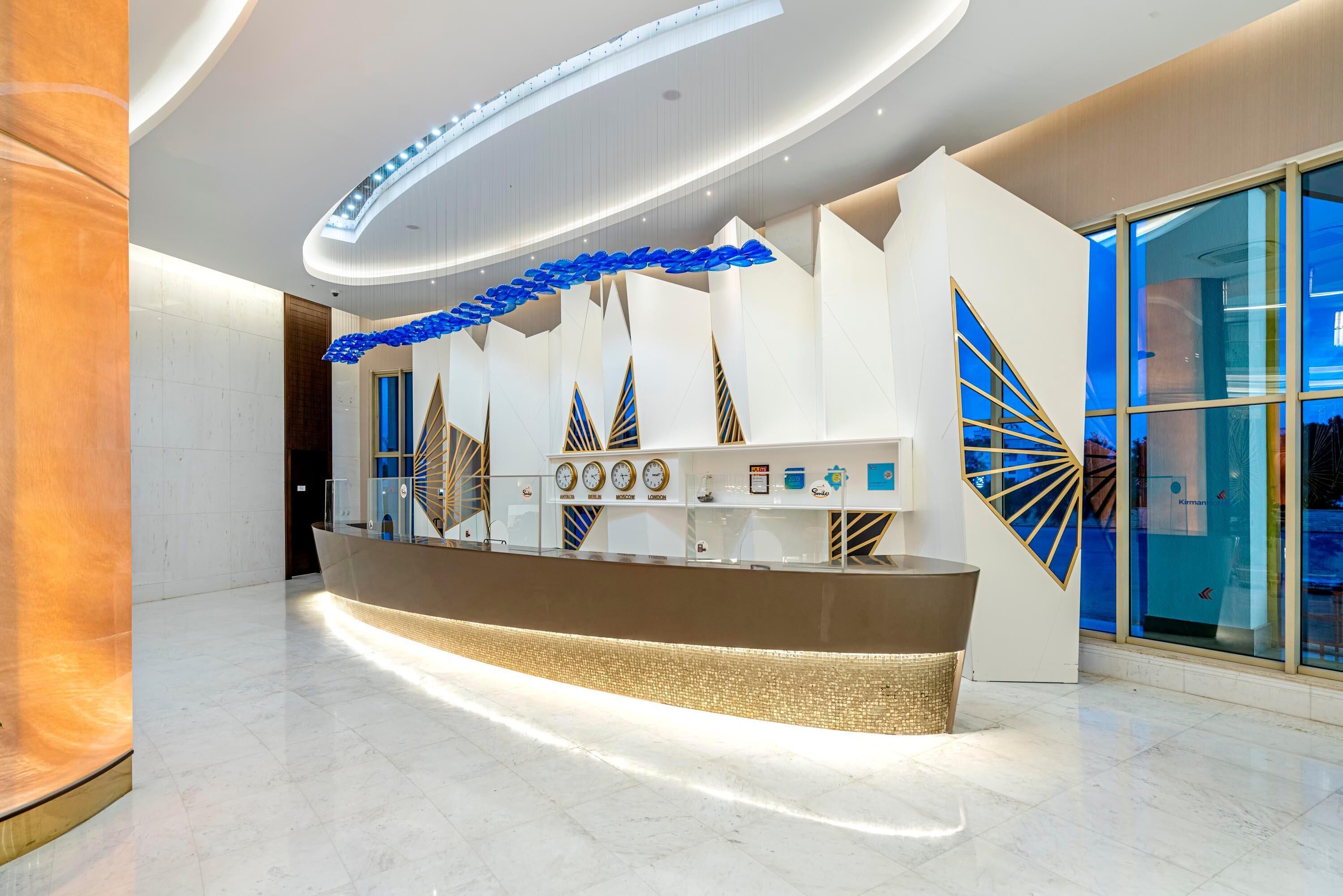 A modern reception area with a curved counter, clocks, and decorative blue elements.