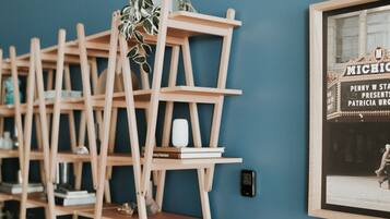 A room with a blue wall, wooden shelving units, and a potted plant.