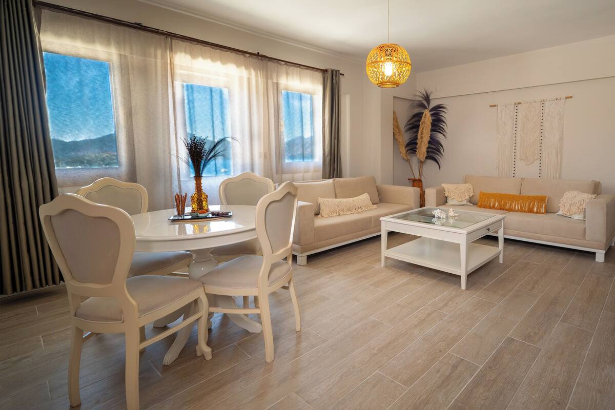 A modern living room with a sofa, coffee table, dining table, and chairs.