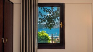 A window with a view of a body of water, a dock, and boats. - Les Terrasses De Selimiye (Marmaris)