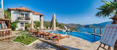 Piscine extérieure, parasols de plage, chaises longues