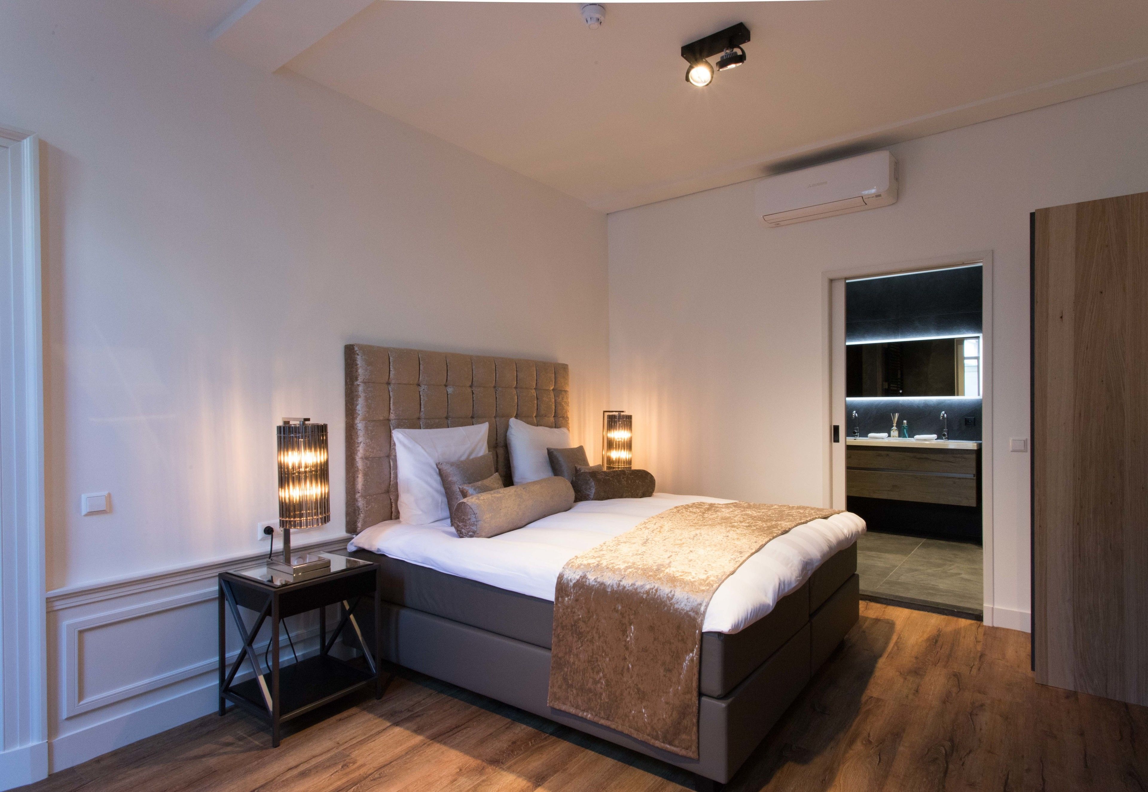 Une chambre moderne avec un grand lit, des lampes de chevet et une armoire intégrée.
