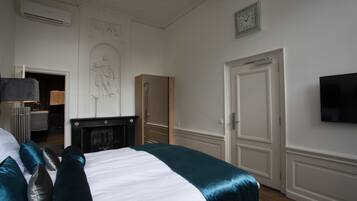 Een hotelkamer met een bed, een televisie, een open haard en een deur.