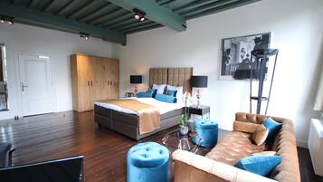 Une chambre à coucher moderne avec un grand lit, un canapé et une table à manger.