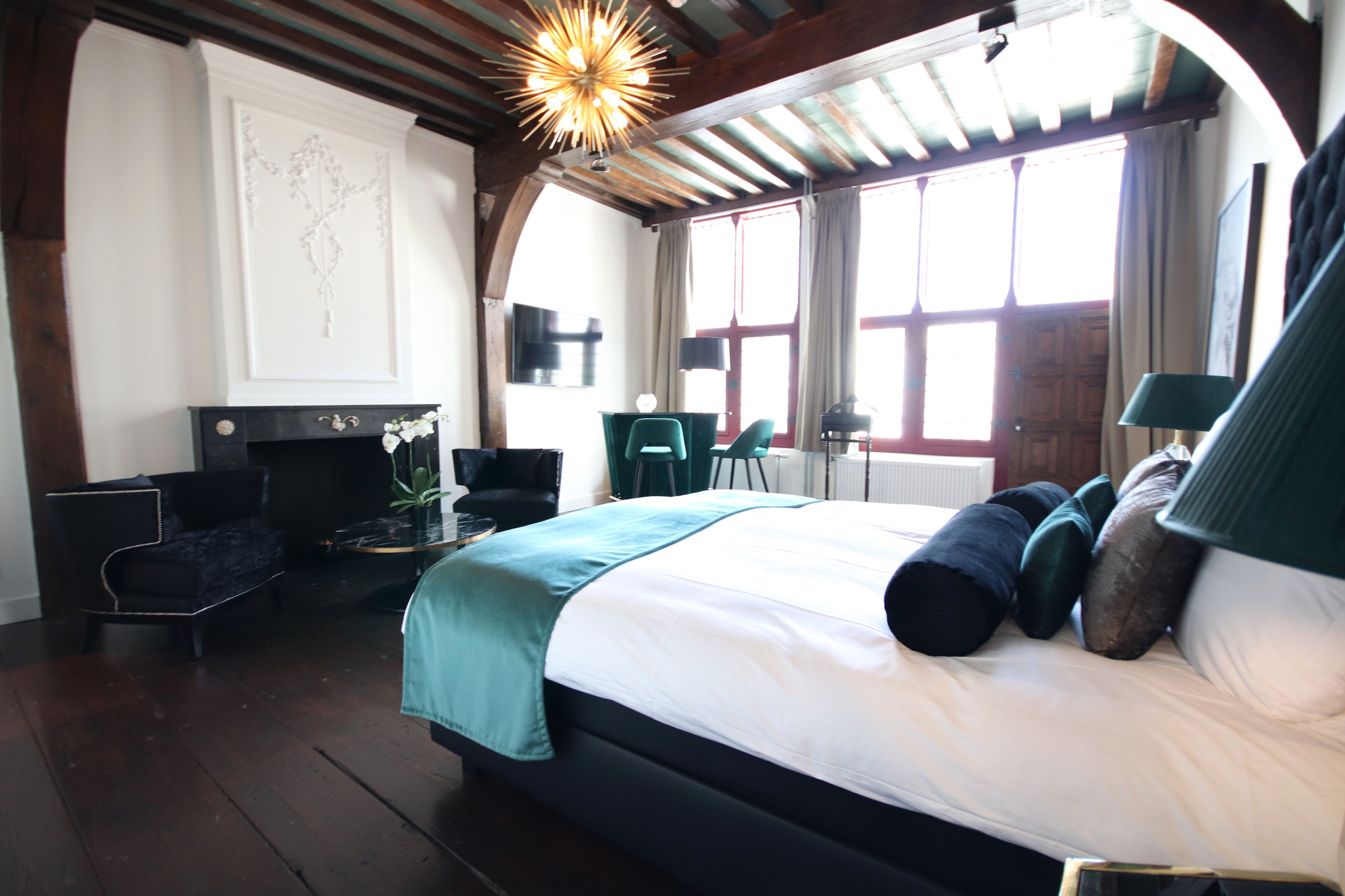 Ein Schlafzimmer mit einem großen Bett, einem Schreibtisch, einem Stuhl und einem Kamin.