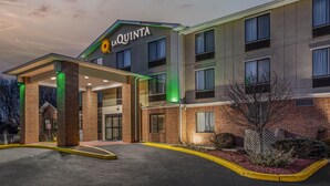 A La Quinta hotel with a modern design, featuring a prominent entrance with a covered walkway and a well-lit facade. - La Quinta Inn & Suites by Wyndham Norwich-Plainfield-Casino (Plainfield)