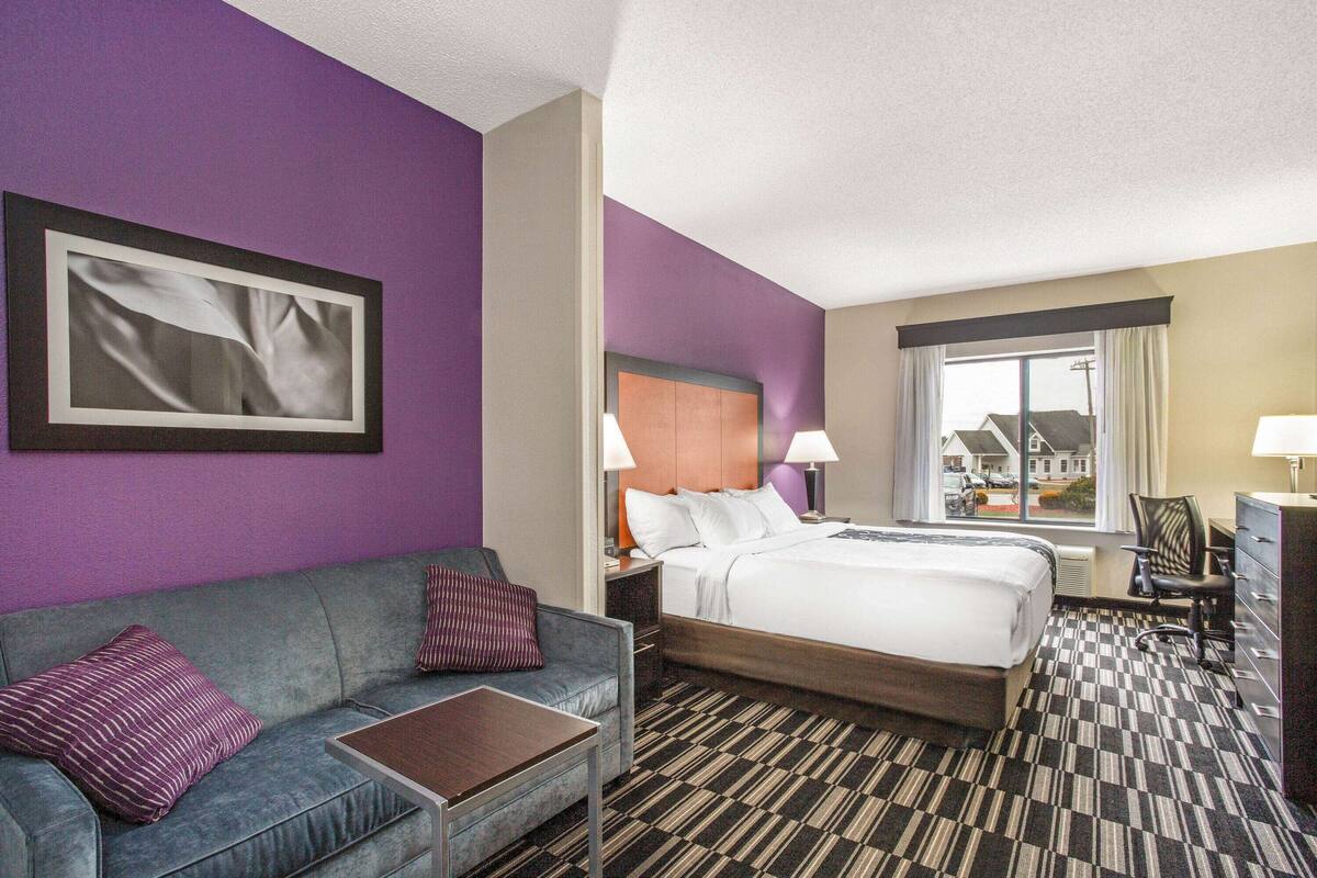 Ein Hotelzimmer mit Bett, einer Sitzecke, einem Schreibtisch und einem Fenster mit Blick.