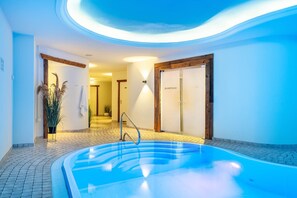 A spa area with a hot tub, wooden doors, and a tiled floor. - SEETELHOTEL Ostseeresidenz Ahlbeck (Heringsdorf)