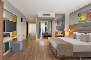 A hotel room with a large bed, a television, a desk, and a chair.