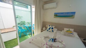 A hotel room with a bed, a painting, an air conditioner, and a view of the outside. - Pousada Bahia Inn (Cairu)