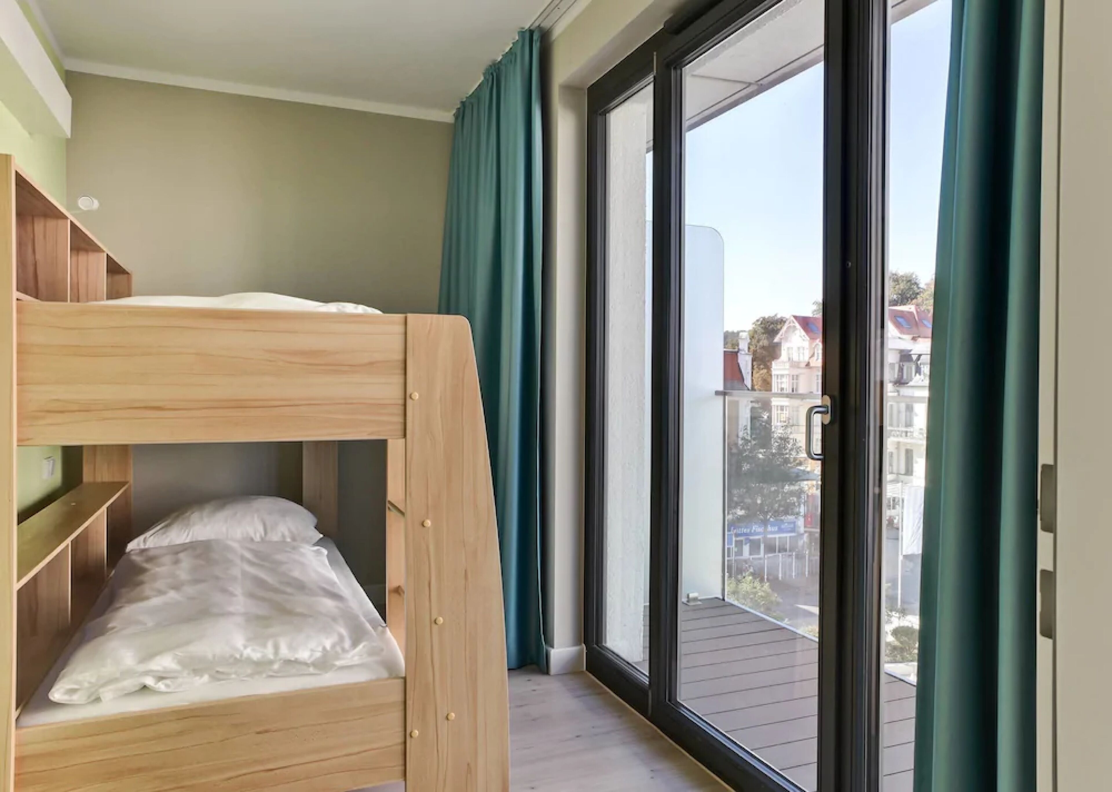 A bunk bed in a room with a large sliding glass door leading to an outdoor balcony.