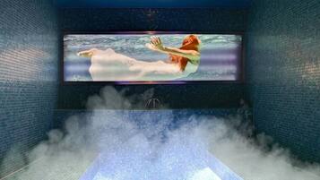 Una gran piscina interior con techo alto y paredes de azulejos.