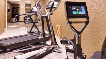Ein Fitnessraum mit Laufbändern, Crosstrainern und einem Ergometer.