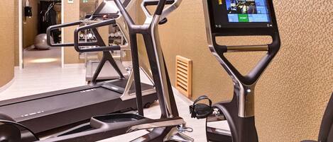 A gym with treadmills, elliptical machines, and a stationary bike.