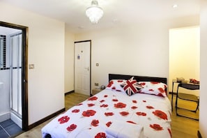 Un dormitorio con cama, candelabro, puerta y una silla.