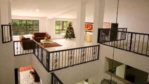 Ein geräumiger Wohnbereich mit Treppe, großen Fenstern und einem Weihnachtsbaum.