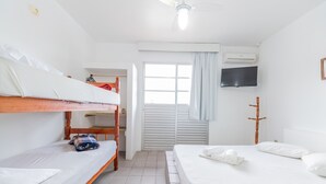 A room with a bunk bed, a single bed, a television, and a window with curtains. - Pousada Santa Ana (Florianópolis)