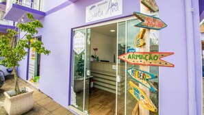 A purple building with a sign reading "Santa Ana" and multiple colorful directional signs. - Pousada Santa Ana (Florianópolis)