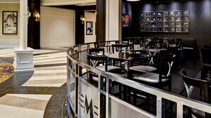 A modern hotel lobby with a curved seating area, chandeliers, and framed artwork on the walls. - Saratoga Casino Hotel (Saratoga Springs)