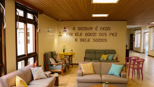 Un área de estar acogedora con dos sofás, una mesita de centro y una pared con una cita inspiradora.