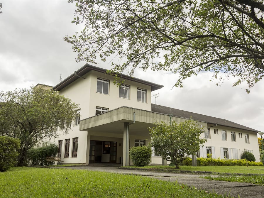 Um edifício de dois andares com uma entrada coberta e um gramado.